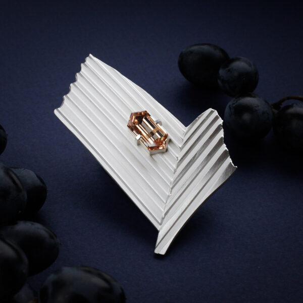 hõbedane triibuline pross šampanjakarva kiviga tumesinisel taustal