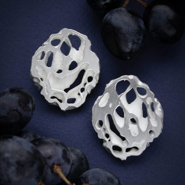 hõbedast orgaanilise mustriga kõrvarõngad, ebakorrapärase kujuga käsitööehted tumedal taustal