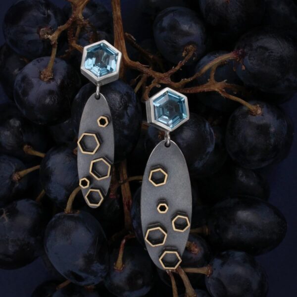 hõbedast ja messingist „Stellar” kõrvarõngad siniste kividega, viinamarjade taustal
