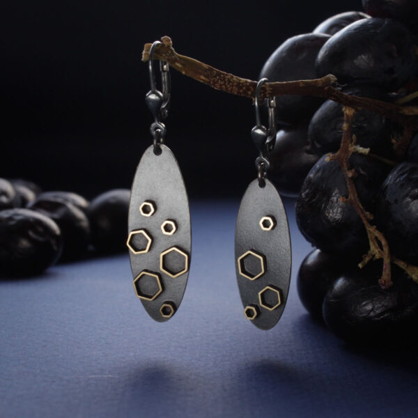 Stellar kollektsiooni tumehõbedased kõrvarõngad kuusnurksete detailidega oksal rippuvalt | Katrin Veegen