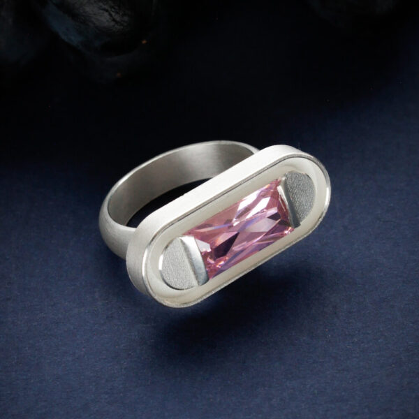 helehõbedast sõrmus pikliku roosa tahutud kiviga, modernne käsitööehe tumedal taustal