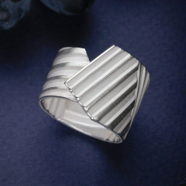 Triibuline hõbedast sõrmus kihilise pinnaga ja kattuva vormiga | Katrin Veegen