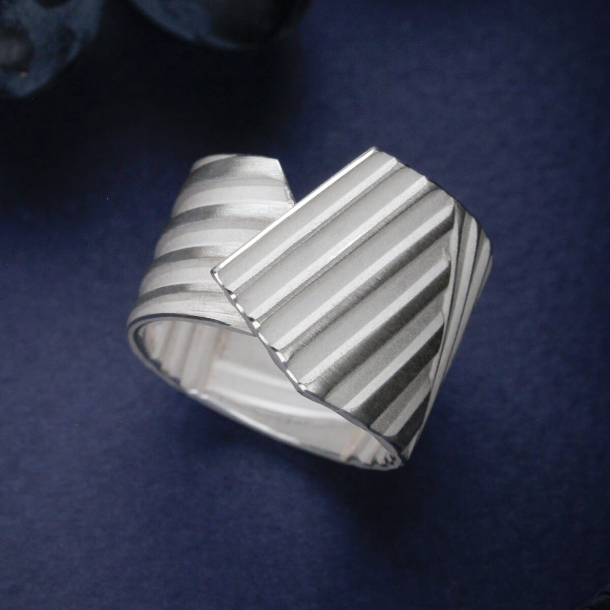 Triibuline hõbedast sõrmus kihilise pinnaga ja kattuva vormiga | Katrin Veegen